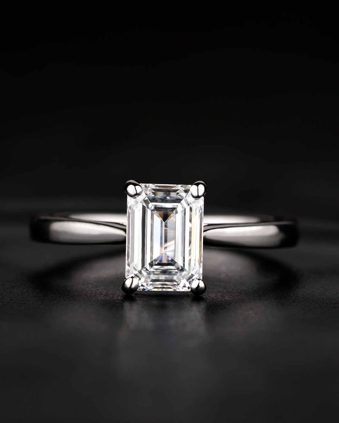 Emerald-cut diamond four-prong solitaire in platinum