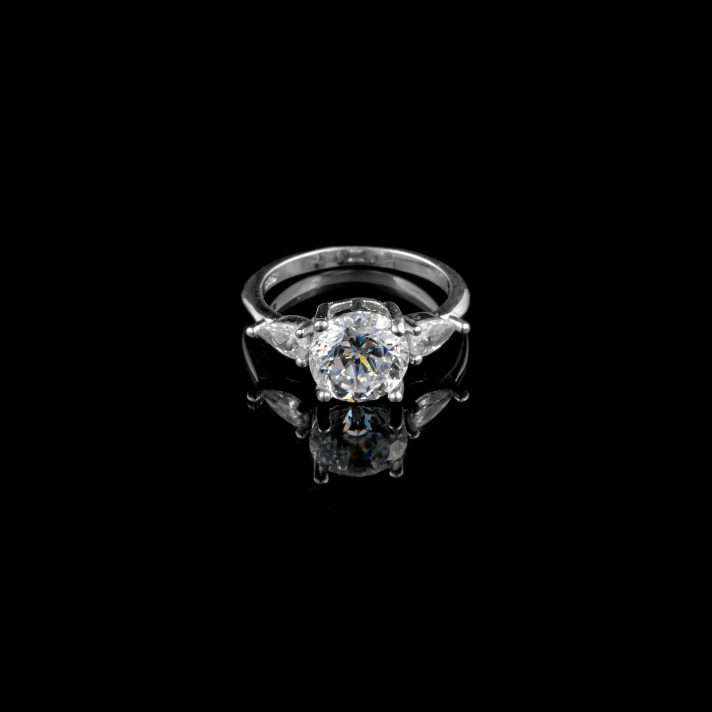 Round diamond flanked by two pear-shaped side stones in white gold