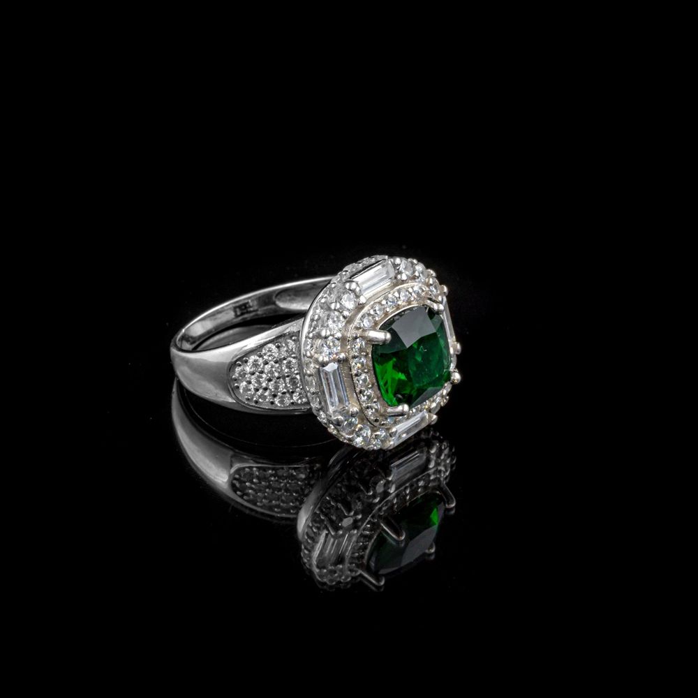 Green cushion-cut center stone in a double halo with baguettes and pavé shoulders, white gold